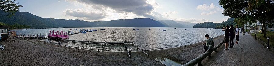 Autumn colours reflected on the still water of Lake Towada