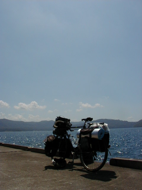 View across the still water of Lake Towada with forested hills behind