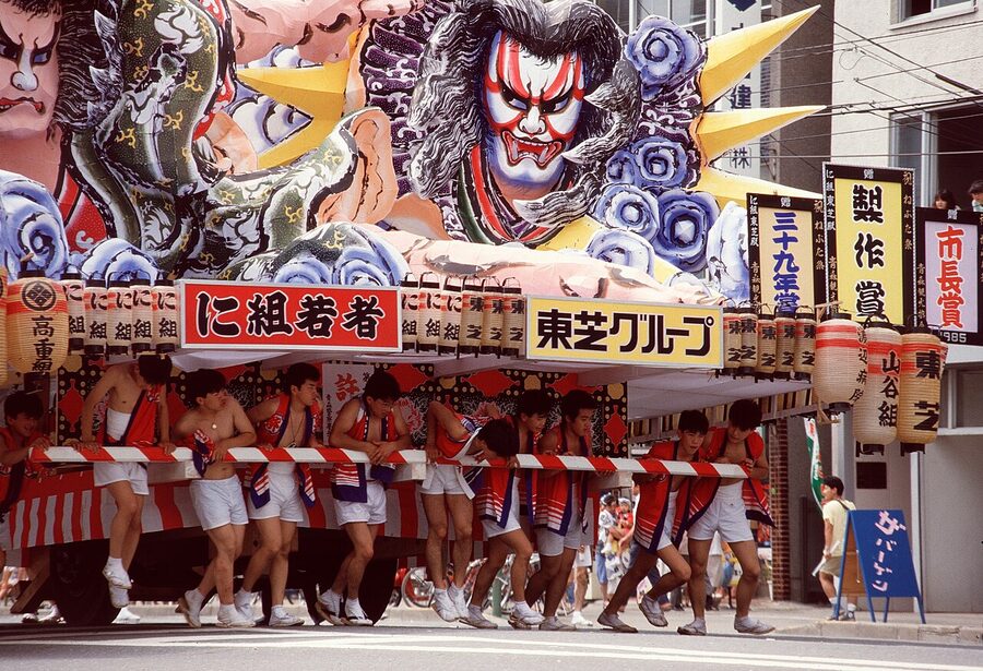 A close-up of a Nebuta float face glowing in the dark