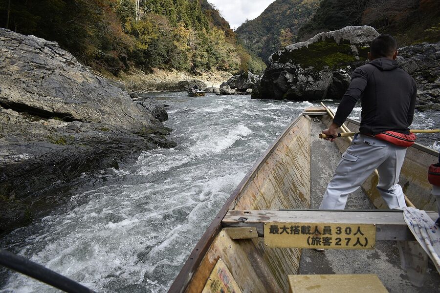 Hozugawa river boat passing under cliffs in canyon between Kameoka and Arashiyama