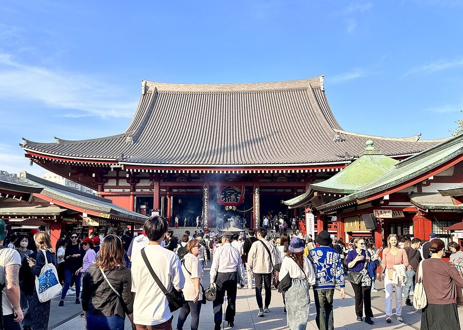 Senso-ji main hall in Asakusa, Tokyo with paper lanterns and worshippers