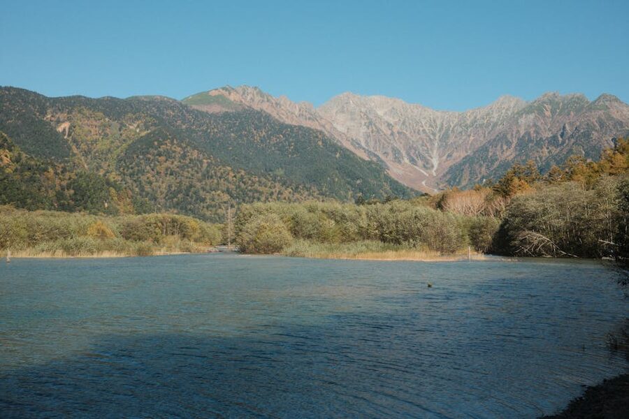 Clear river running through Kamikochi National Park surrounded by forested mountains