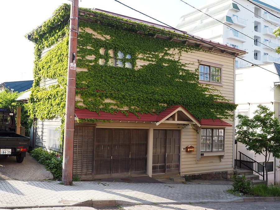 A sloped Motomachi street with a Russian Orthodox church spire and the harbour beyond.