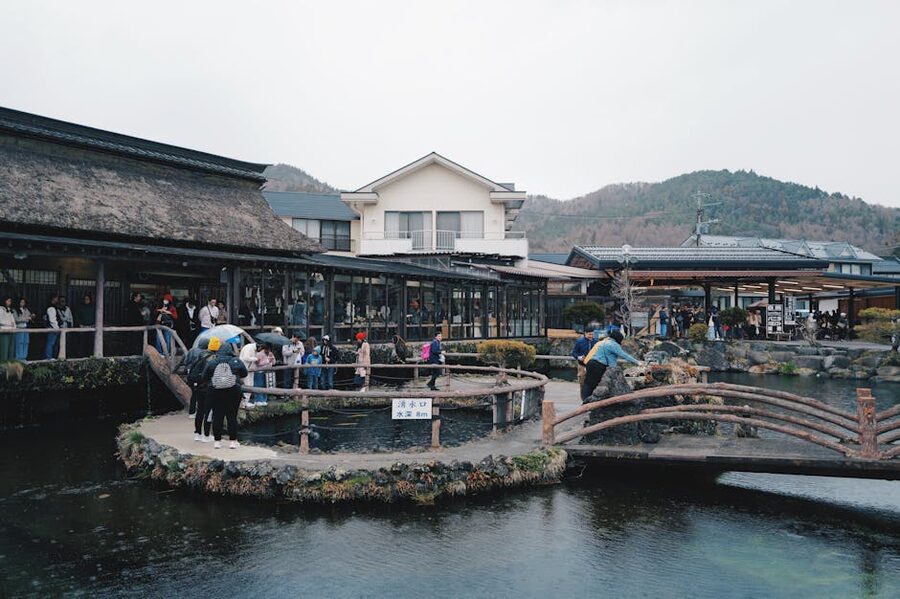 Traditional thatched-roof houses at Oshino Hakkai village with Mt. Fuji rising behind
