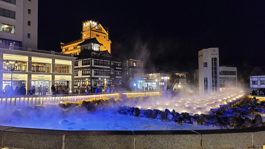 Yubatake wooden cooling channels at Kusatsu Onsen with steam rising