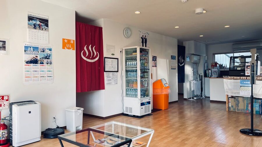 Reception area of a Japanese onsen with vending machines and signage