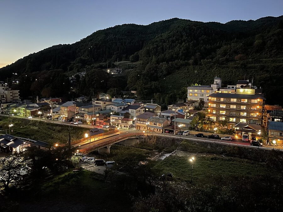Shibu Onsen stone-paved street at night, ryokan facades lit