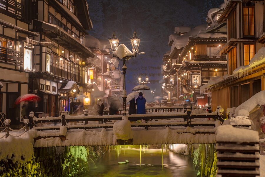 Outdoor onsen bath in winter with snow falling
