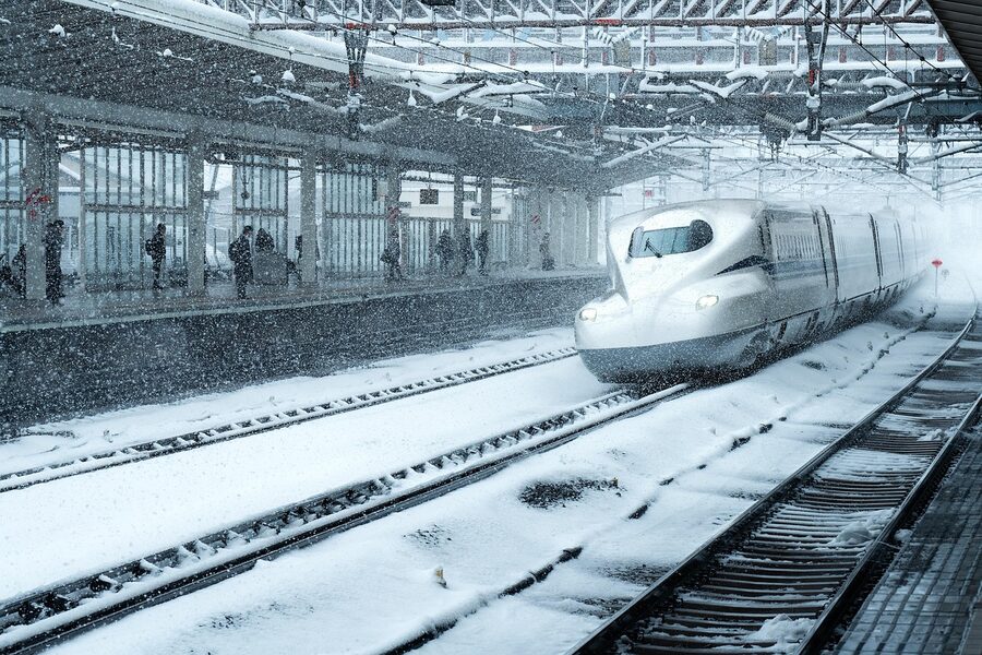 Shinkansen passing through a snowy platform