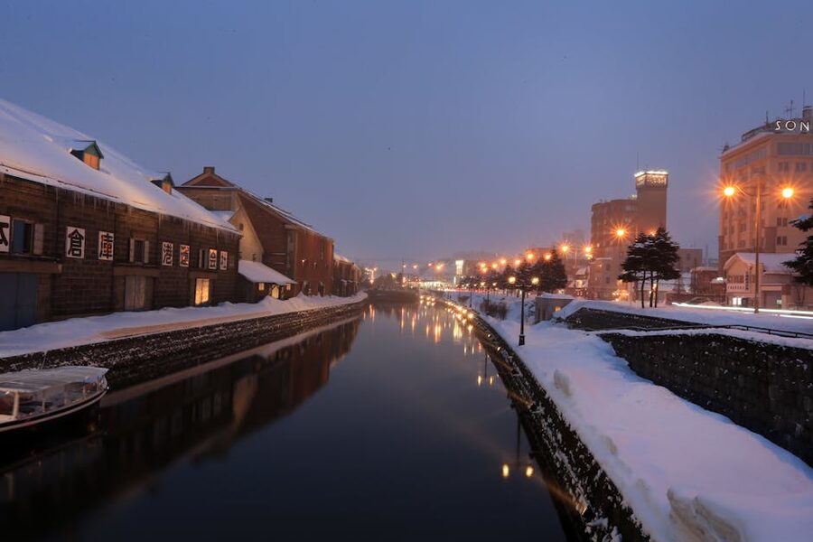 The Otaru Canal at dusk in winter, with snow on the banks and gas lamps coming on
