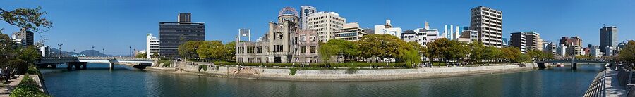 Panoramic view of the A-Bomb Dome in Hiroshima Peace Memorial Park, river in foreground.