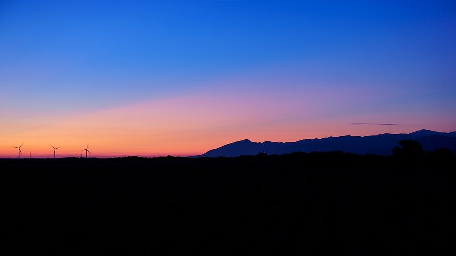 The Shirakami Mountains at twilight, beech-forested ridges fading into purple distance.