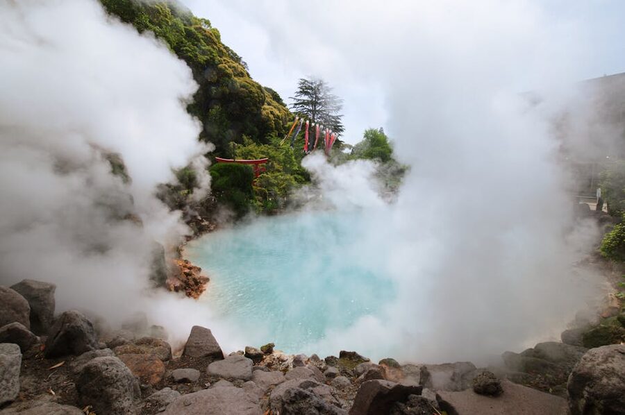Steam rising from a Beppu hot spring with rocky surroundings