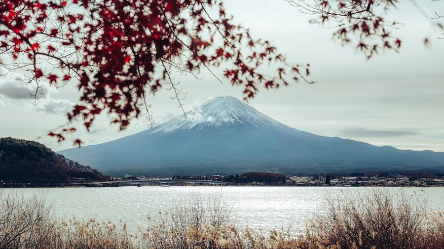Mount Fuji in autumn over Lake Kawaguchi with red leaves and reflection