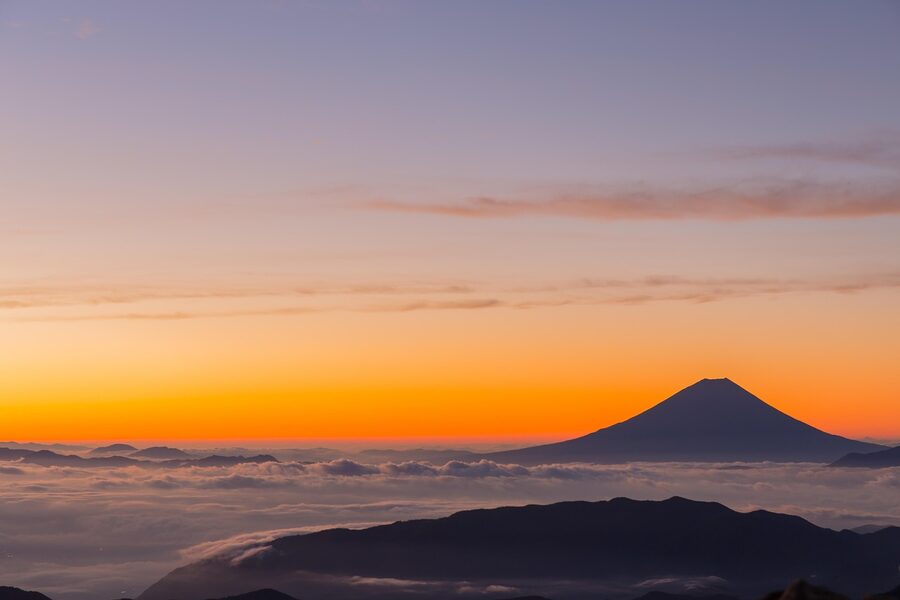 Mount Fuji peak above a sea of clouds at sunrise