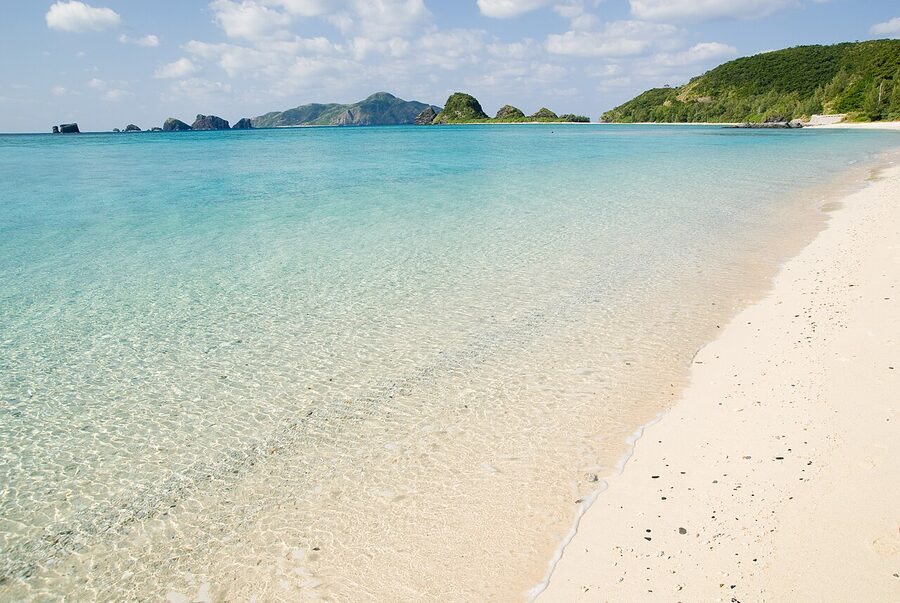 Furuzamami Beach on Zamami Island, white sand crescent and coral seabed visible through clear water