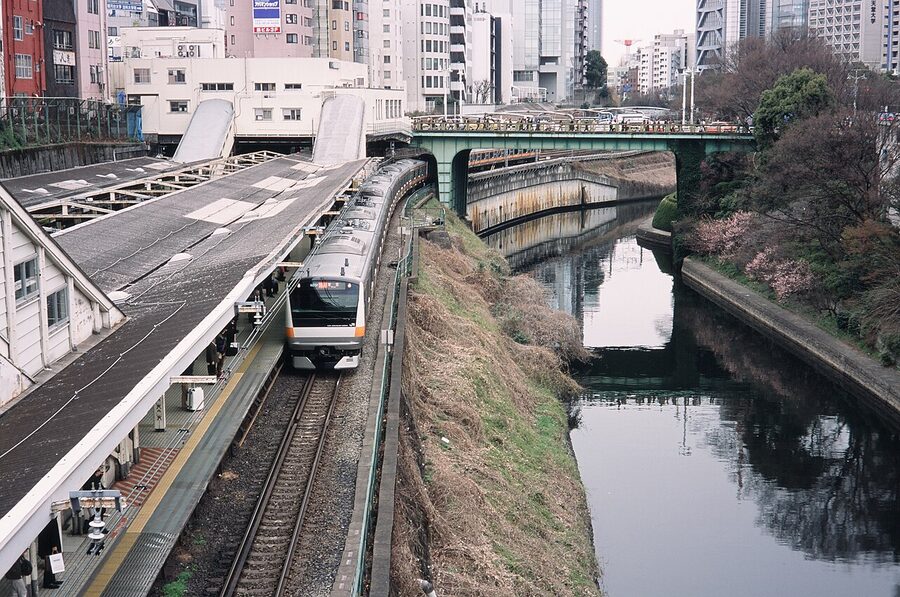 Cherry blossoms framing JR Ochanomizu station and Tokyo trains