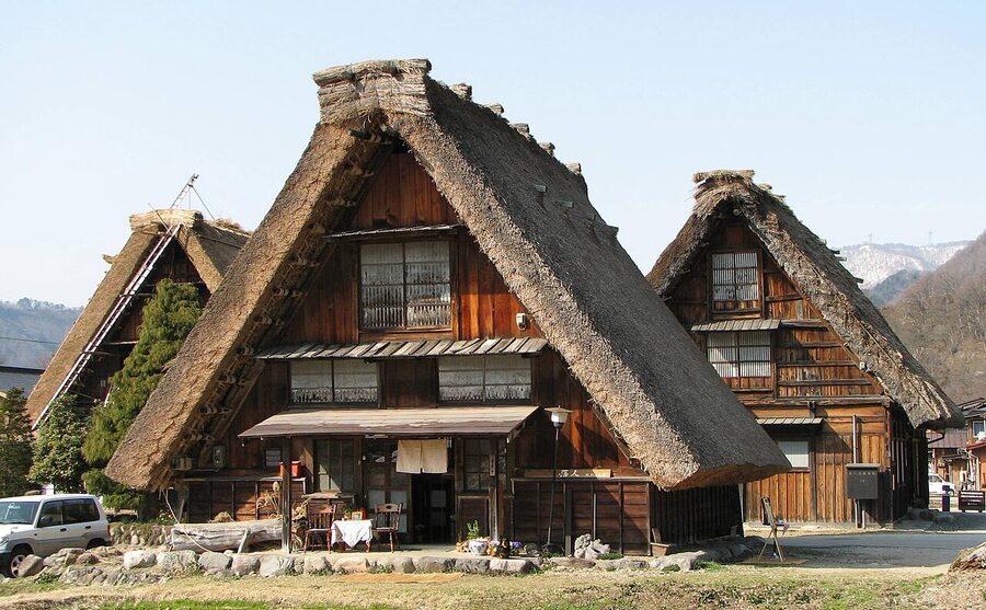 Close view of a gassho-zukuri farmhouse showing the steep thatched A-frame roof structure