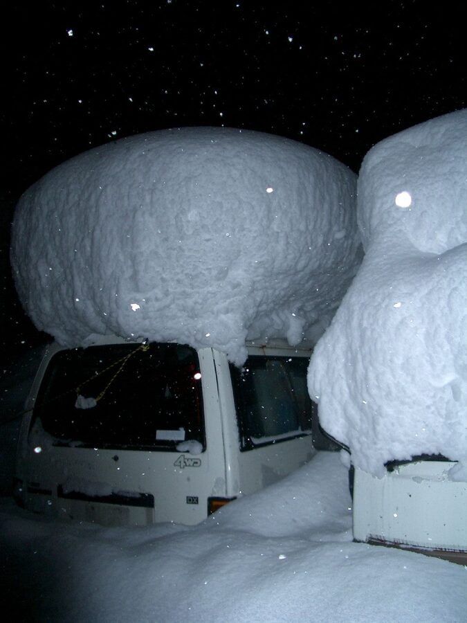A car covered in heavy snow in winter Japan, illustrating the conditions to drive to Shirakawa-go