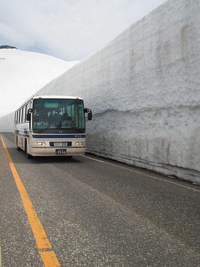 Snow walls towering above pedestrians on the Tateyama Snow Wall walking section