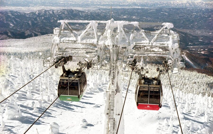 Twin gondolas crossing snow-covered Mt Zao